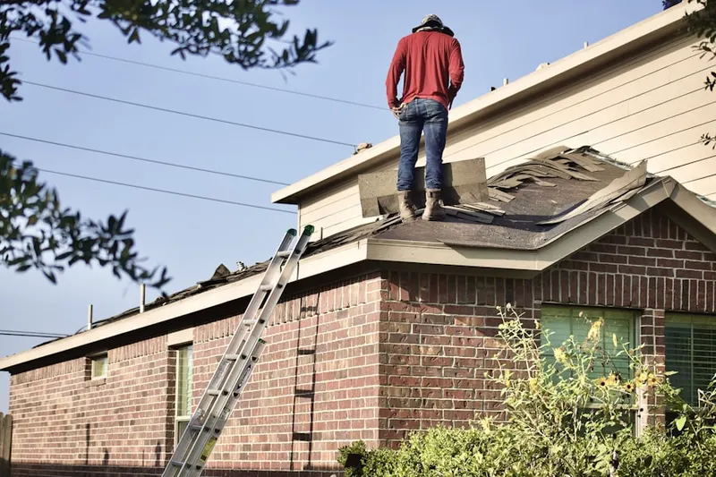 Professional roofer working on a residential roof in Conley